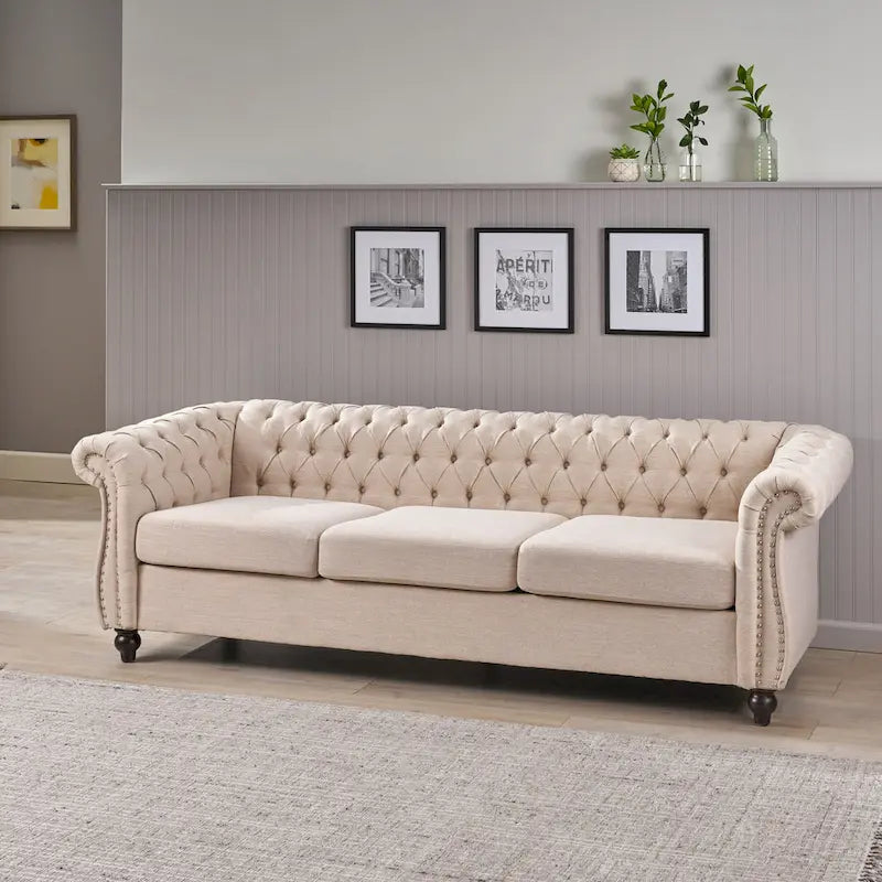 Beige tufted three-seater sofa, adorned with rivets