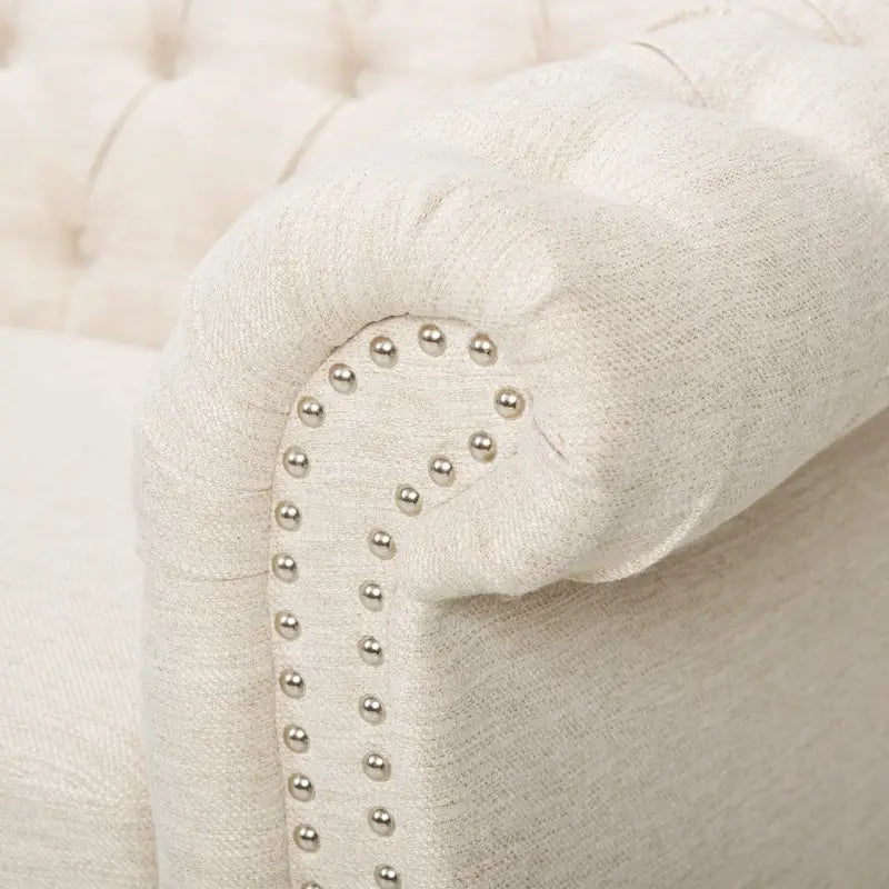 Beige tufted three-seater sofa, adorned with rivets
